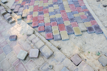 Close-up of construction installing and laying pavement stones on terrace, road or sidewalk.