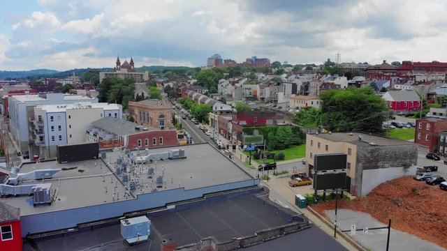 A slow forward aerial push establishing shot of the business district of Lawrenceville, a Pittsburgh neighborhood experiencing the benefits of gentrification.  	