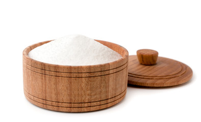 Salt in a wooden plate on a white, close-up.