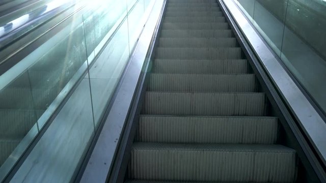 POV 4K video clip riding an escalator up from an underground railway station into city daylight
