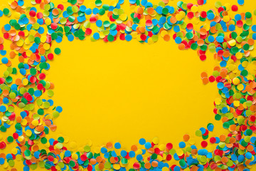 Colorful Confetti in front of orange Background.