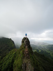 person standing on top of a mountain peak in hawaii