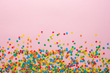 Frame made of colored confetti. Pink background.