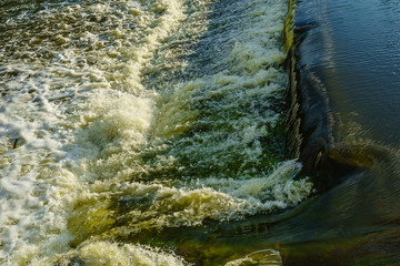 Seething water with foam, threshold on the river