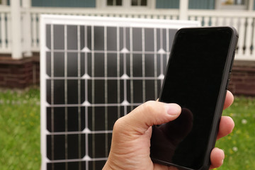 Smartphone and solar panel. Energy production technologies. Saving on renewable energy and solar panels.