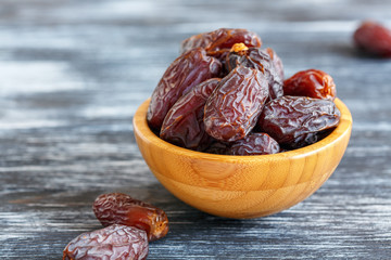 Dried fruits of date palm in a wooden bowl.