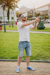 A young man plays a game wearing virtual reality glasses on the street.