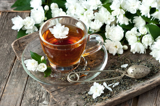 Jasmine flowers  and cup of tea on rustic background