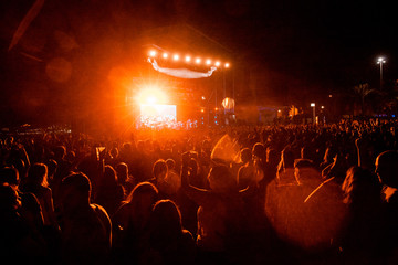 View of a concert with people or audience with hands in the air and clapping at a music festival....