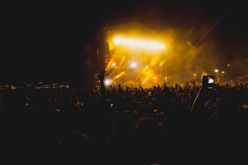View of a concert with people or audience with hands in the air and clapping at a music festival. Summer music festival.