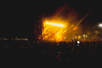 View of a concert with people or audience with hands in the air and clapping at a music festival. Summer music festival.