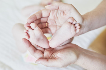 feet of a newborn in mother's hands