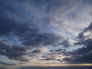 Dramatic cloudscape with gray clouds and blue sky during sunset 