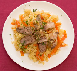 Rice with meat close-up on a red background