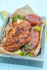 Grilled chicken breast served with herbs and lime