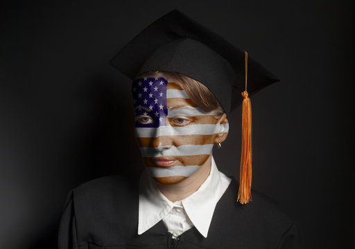Portrait of Female American bachelor with painted USA Flag in Black mantle and Graduation Cap