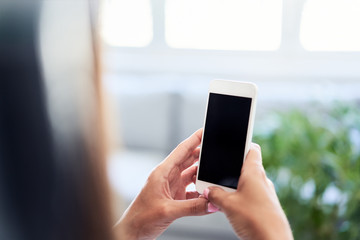 Closeup of woman using smartphone at home