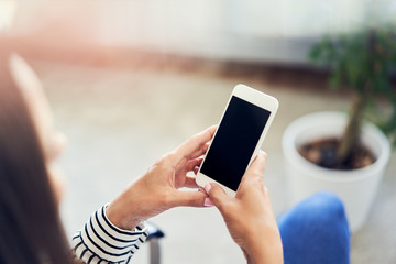 Close-up of woman using smartphone at home