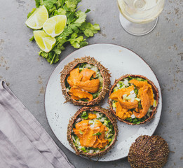 Fresh opened sea urchins. Caviar of sea urchins with onion, cilantro and lemon inside of shell of sea urchins. Top view