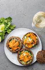 Fresh opened sea urchins. Caviar of sea urchins with onion, cilantro and lemon inside of shell of sea urchins. Top view