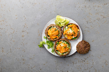 Fresh opened sea urchins. Caviar of sea urchins with onion, cilantro and lemon inside of shell of sea urchins. Top view