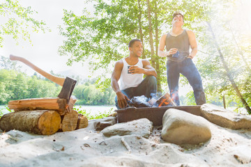 African American Man and Mixed Race Man Enjoying The Morning Campfire Outdoors