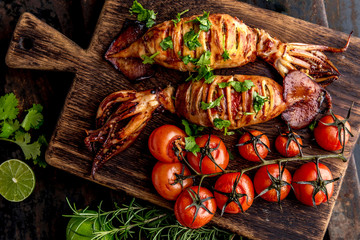 Korean BBQ squid calamary and ingredients on dark background. Traditional korean dish - grilled...