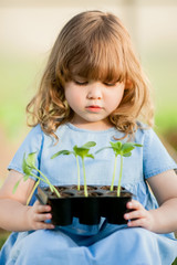 Adorable little girl in the greebhouse