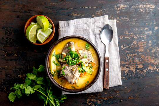 CHILEAN FOOD. Fish soup CALDILLO DE CONGRIO served in clay bowl, top view. copy space