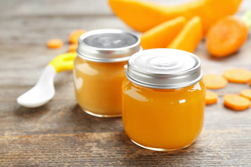 Jars with tasty baby food on table