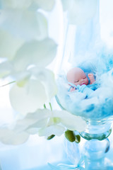 Party decorations details: tiny newborn boy doll with bottle of milk