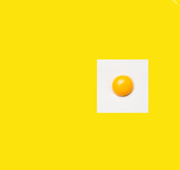 Square egg on yellow background. Minimalistic design, colorful background
