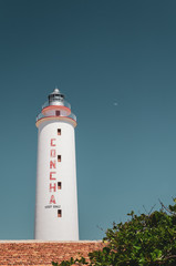 Concha lighthouse against blue sky with moon in Punta de Maisi, Guantanamo Cuba