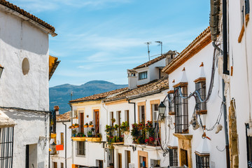 Fototapeta na wymiar narrow street with white facades of houses in historic district of Ronda, Spain