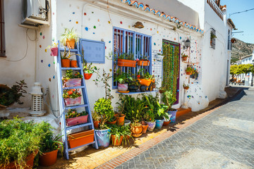 decorated facade of house with flowers in blue pots in Mijas, Spain