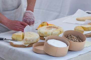 The seller on a marketplace sells handmade cheese, close-up