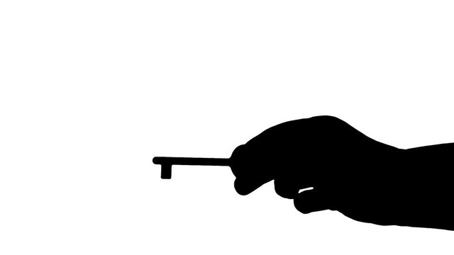 A female hand showing an old rusty key. Silhouette medium shot.
