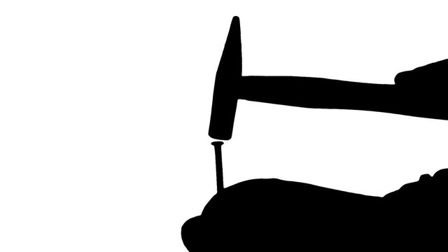 A female hand holding a big rusty nail still and hitting it on the head with a hammer. Silhouette shot.
