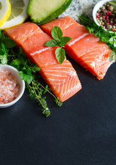 fresh salmon fillet on black stone surface