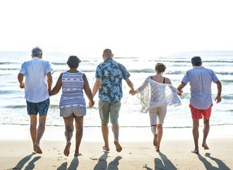 Obraz premium Senior friends enjoying the beach in the summertime