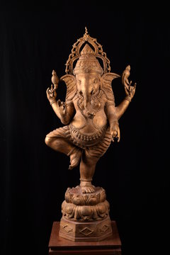 Lord Ganesha standing bronze statue on black background..