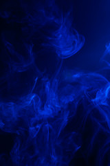 Blue smoke on black background.