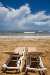 Two chairs and umbrella on stunning tropical beach