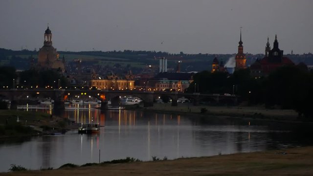 Evening in Dresden: The historic Altstadt skyline lights turn on and bats flying all over the Elbe River (Saxony, Germany)