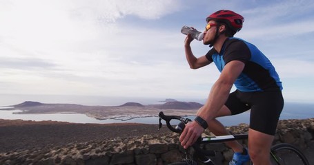 Athlete cyclist man drinking water during cycling biking training, Healthy active lifestyle sports fitness man exercising outside. SLOW MOTION RED EPIC.