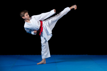 Young boy dressed in a white karate kimono with red belt. © FS-Stock