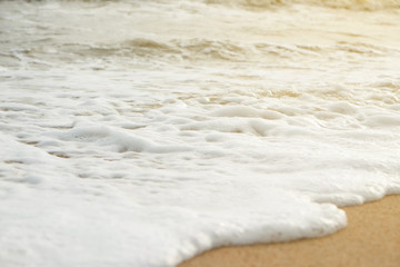 Soft ocean wave on sandy beach.