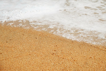 Soft ocean wave on sandy beach.