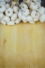Fresh raw garlic bundle on cutting board, copy space, kitchen raw ingredient concept