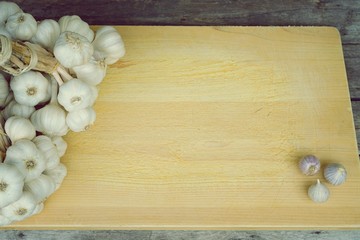 Fresh raw garlic bundle on cutting board, copy space, kitchen raw ingredient concept